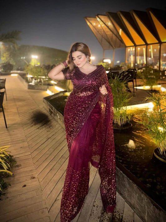 Woman in a purple saree on a rooftop at night